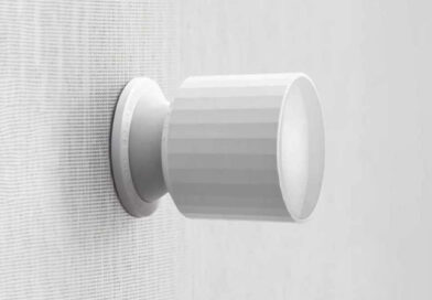 The Qingping Motion Sensor T with HomeKit over Thread, mounted to a vertical muslin type surface in light grey.